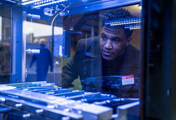 Image of a student examining information technology infrastructure in an on-campus lab.